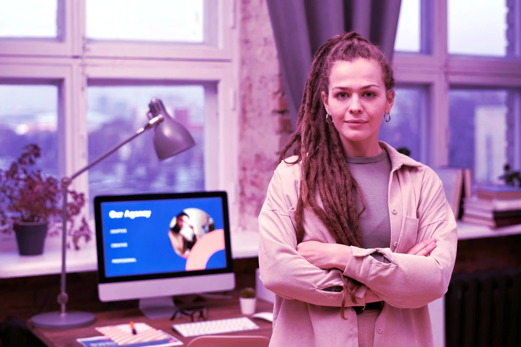 A creative agency professional in her studio, with an 'Our Agency' presentation on screen behind her