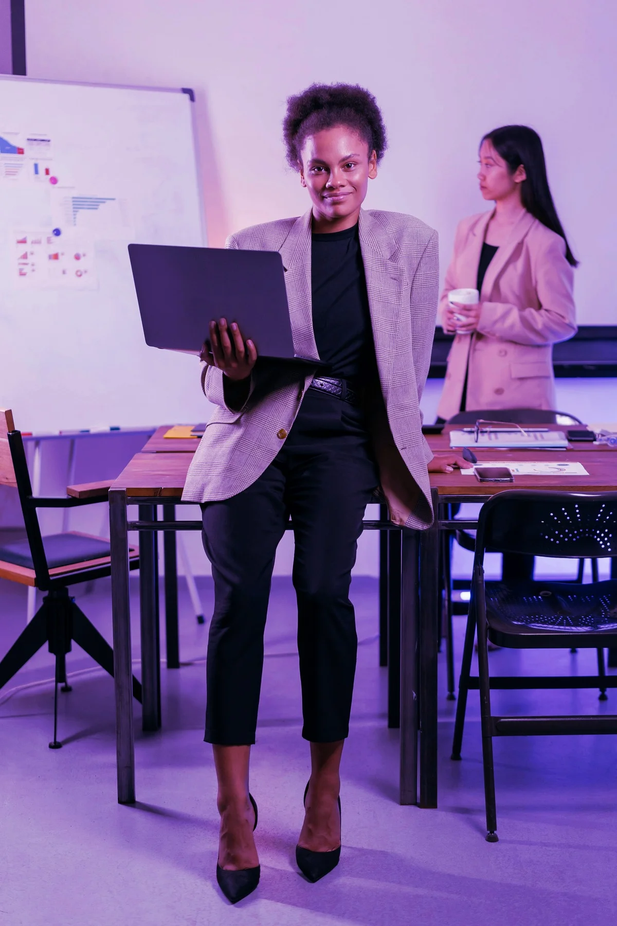 A brand marketer reviewing podcast performance on a laptop with a colleague